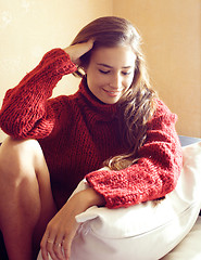 Image showing young pretty real woman in red sweater and scarf all over her fa