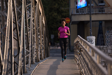 Image showing african american woman running across the bridge