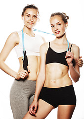 Image showing two sport girls measuring themselves isolated on white