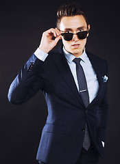 Image showing young pretty business man standing on black background, modern h