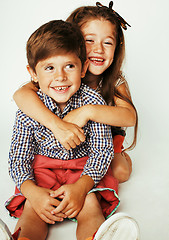 Image showing little cute boy and girl hugging playing on white background, ha