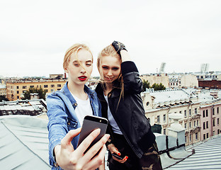 Image showing two cool blond real girls friends making selfie on roof top, lif