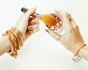 Image showing woman hands with golden manicure and many rings holding brushes,