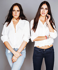 Image showing two sisters twins posing, making photo selfie, dressed same whit