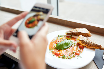 Image showing hands with gazpacho soup photo on smartphone 