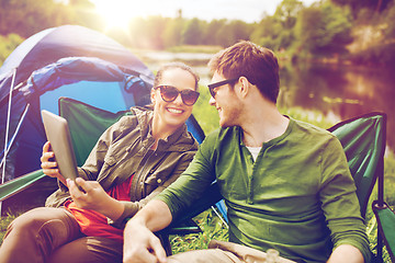 Image showing happy couple with tablet pc at camping tent