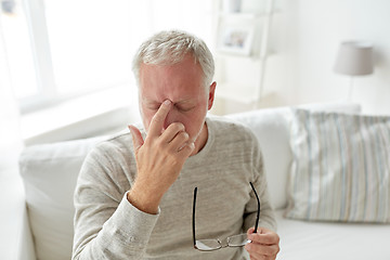 Image showing senior man suffering from headache at home