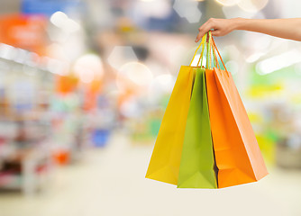 Image showing hand with shopping bags over supermarket