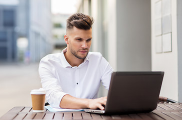 Image showing man with laptop and coffee at city cafe