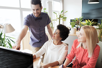 Image showing happy creative team with computer in office