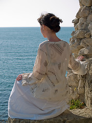 Image showing Lonely Young Woman on Stone Looking to Sea