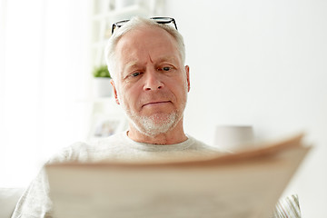 Image showing close up of senior man reading newspaper at home