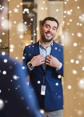 Image showing man trying jacket on at mirror in clothing store