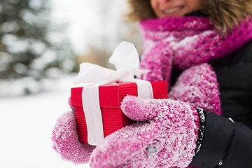 Image showing close up of woman with christmas gift outdoors