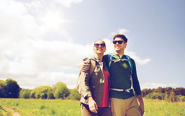 Image showing happy couple with backpacks hiking outdoors