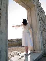 Image showing Barefoot Girl Looking Straight Holding Ancient Ruins