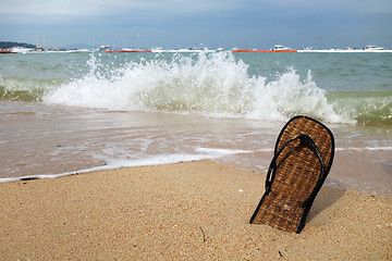 Image showing Beach slippers on a sandy beach