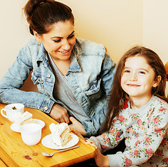 Image showing young mother with daughter on kitchen drinking tea together hugg