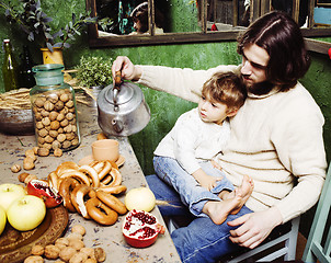 Image showing father with beard holding son at countryside vintage kitchen close up