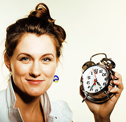Image showing young beauty woman in business style costume waking up for work early morning on white background with clock