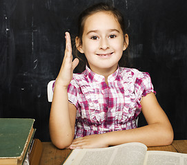 Image showing cute little real girl pupil in classroom at blackboard writting, girl school, ready to answer