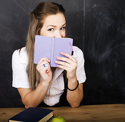 Image showing portrait of happy cute student with book in classroom