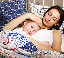 Image showing Portrait of mother and daughter laying in bed and smiling