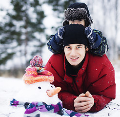 Image showing portrait of happy father with his son outside with snowman, lifestyle people concept