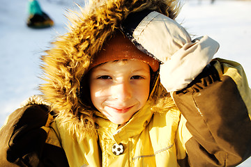 Image showing little cute boy in hood with fur on snow outside