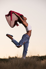 Image showing black girl dances outdoors in a meadow