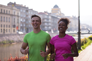 Image showing young multiethnic couple jogging in the city