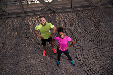 Image showing portrait of a young multiethnic couple jogging in the city