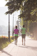 Image showing young multiethnic couple jogging in the city