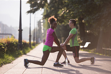 Image showing jogging couple warming up and stretching in the city