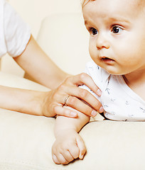 Image showing little cute toddler baby boy playing on chair, mother insures holding hand, lifestyle people concept