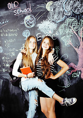 Image showing back to school after summer vacations, two teen real girls in classroom with blackboard painted together