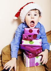 Image showing little cute boy with Christmas gifts at home. close up emotional