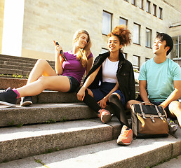 Image showing cute group of teenages at the building of university with books 