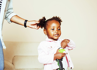 Image showing modern young happy african-american family: mother combing daughters hair at home, lifestyle people concept