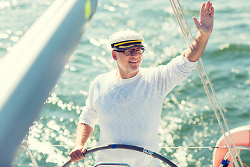 Image showing senior man at helm on boat or yacht sailing in sea