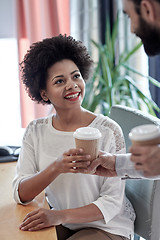 Image showing happy woman taking coffee from man in office