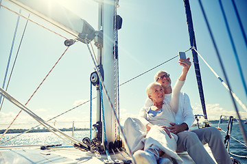 Image showing seniors with smartphone taking selfie on yacht