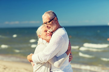 Image showing happy senior couple hugging on summer beach