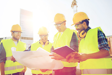 Image showing group of builders with tablet pc and blueprint