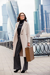 Image showing beautiful smiling businesswoman in a light coat