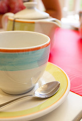 Image showing tea cup with a spoon of sugar on table
