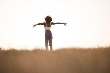 Image showing young black girl dances outdoors in a meadow