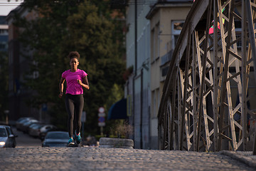 Image showing african american woman running across the bridge