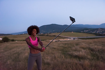 Image showing black woman photographing herself in nature