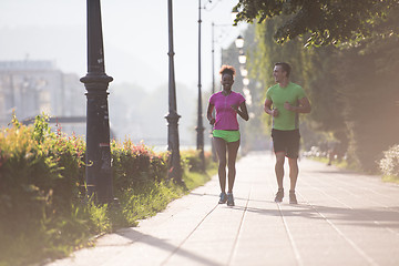 Image showing young multiethnic couple jogging in the city